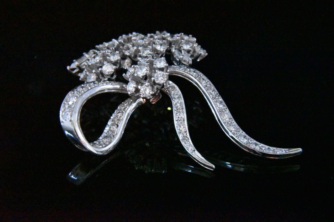 Diamond bow brooch in white gold.