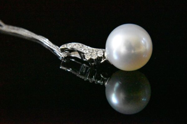 Elegant pearl pendant with diamond clasp.