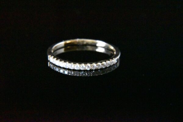 Diamond eternity band on black background.