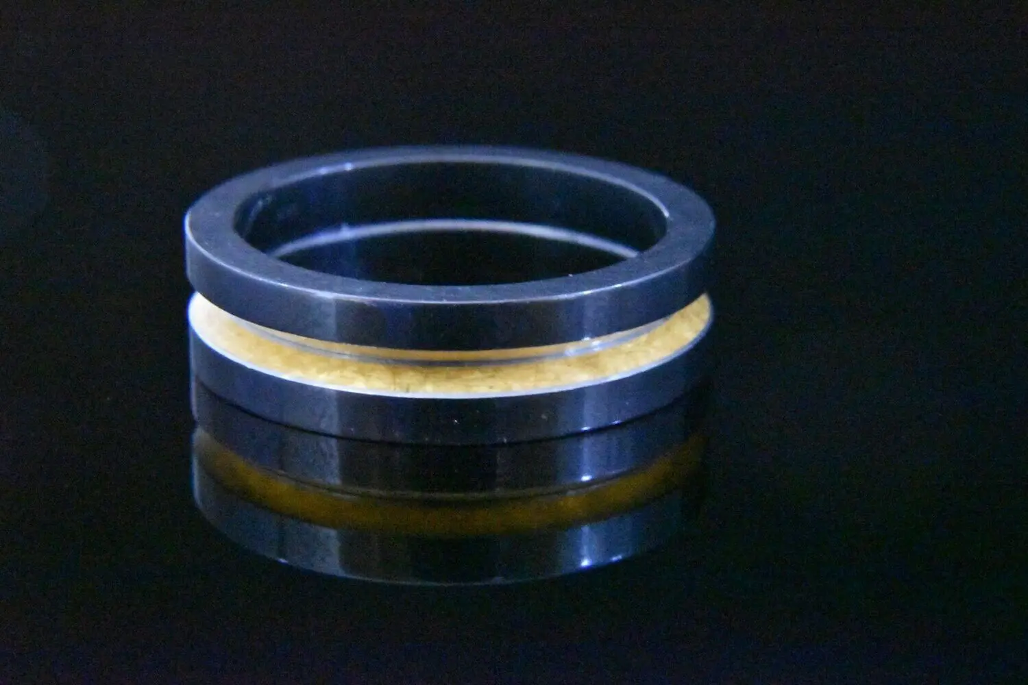 Black ring with gold inlay detail.