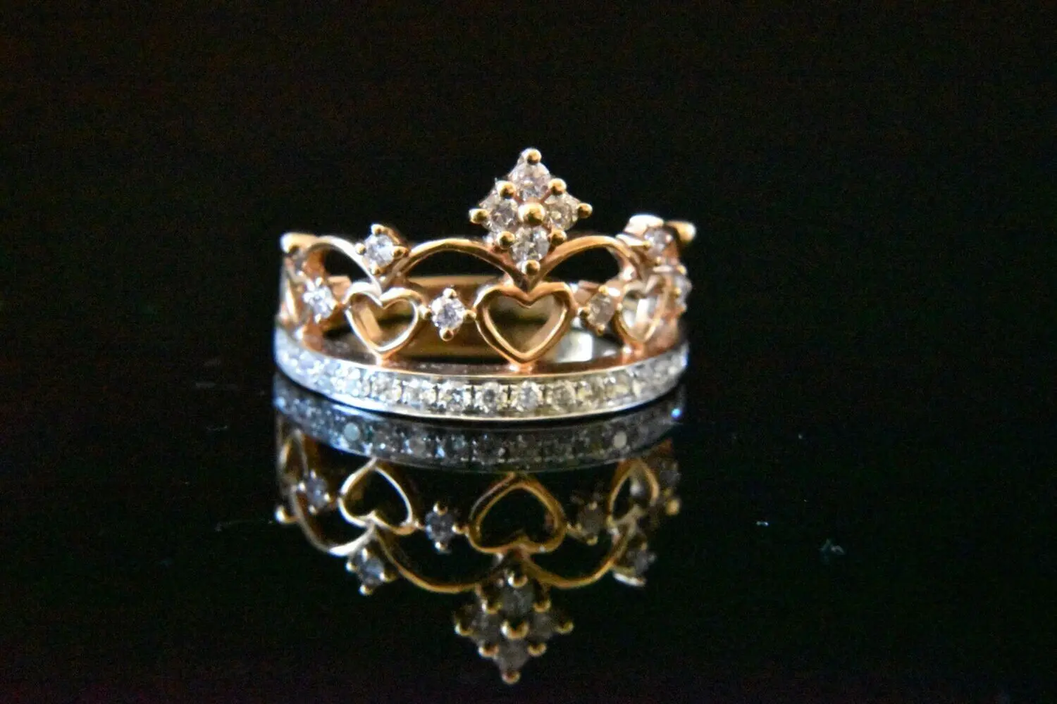 Diamond crown ring on black background.