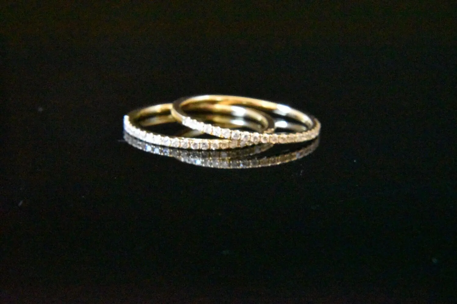 Here's an alt tag for the image: Two gold diamond eternity bands.