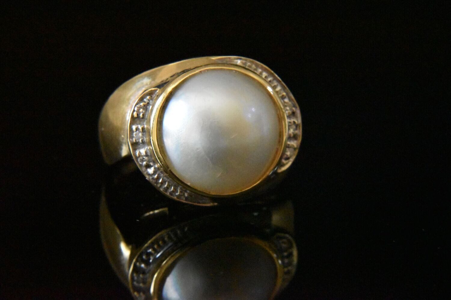 Gold ring with large pearl and diamonds.