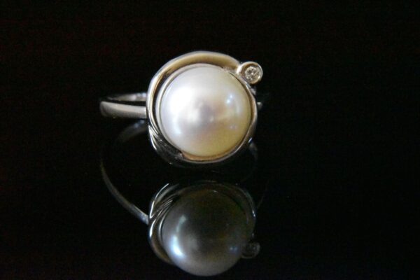 Elegant pearl ring with diamond accent.