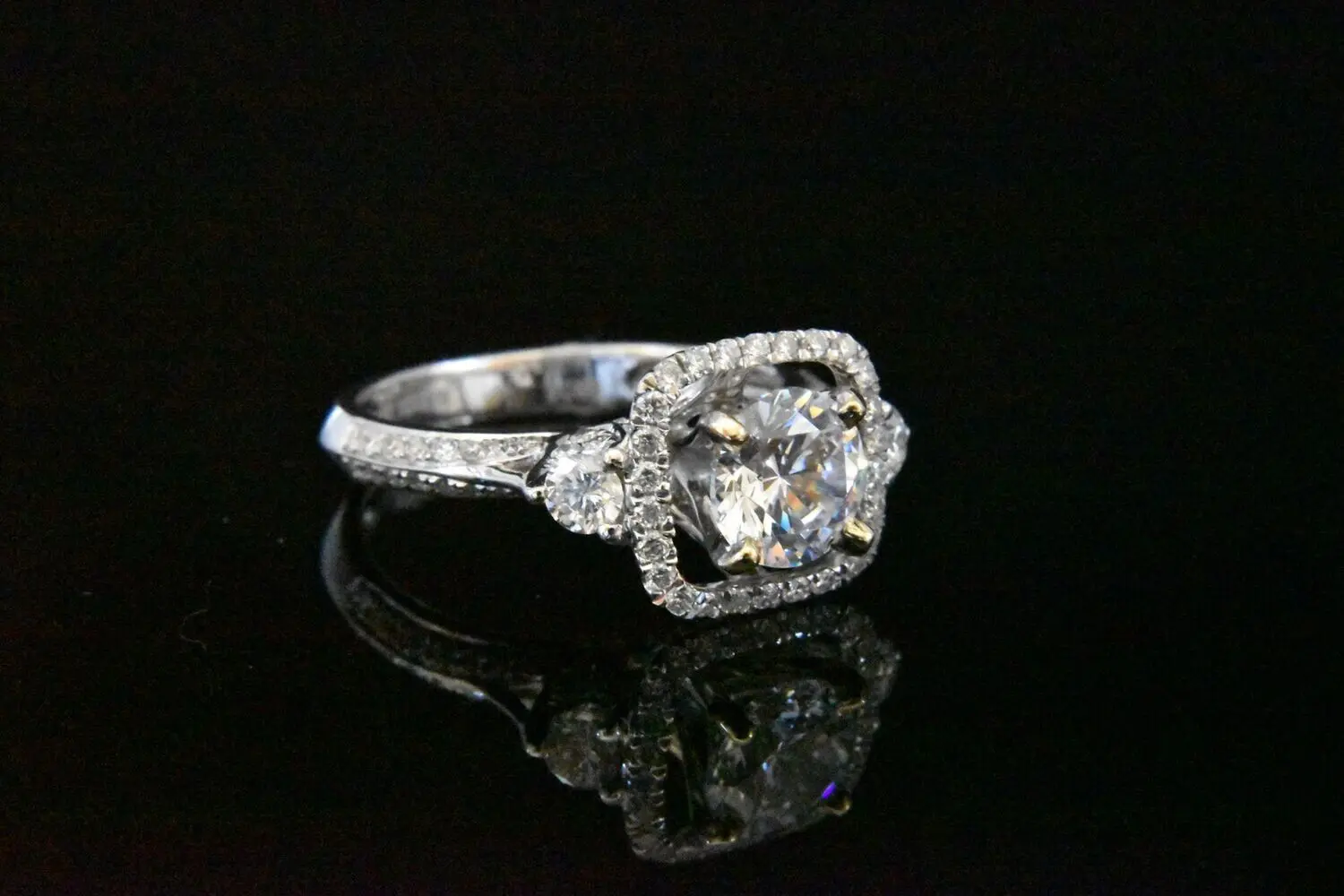 Diamond halo engagement ring with side stones.