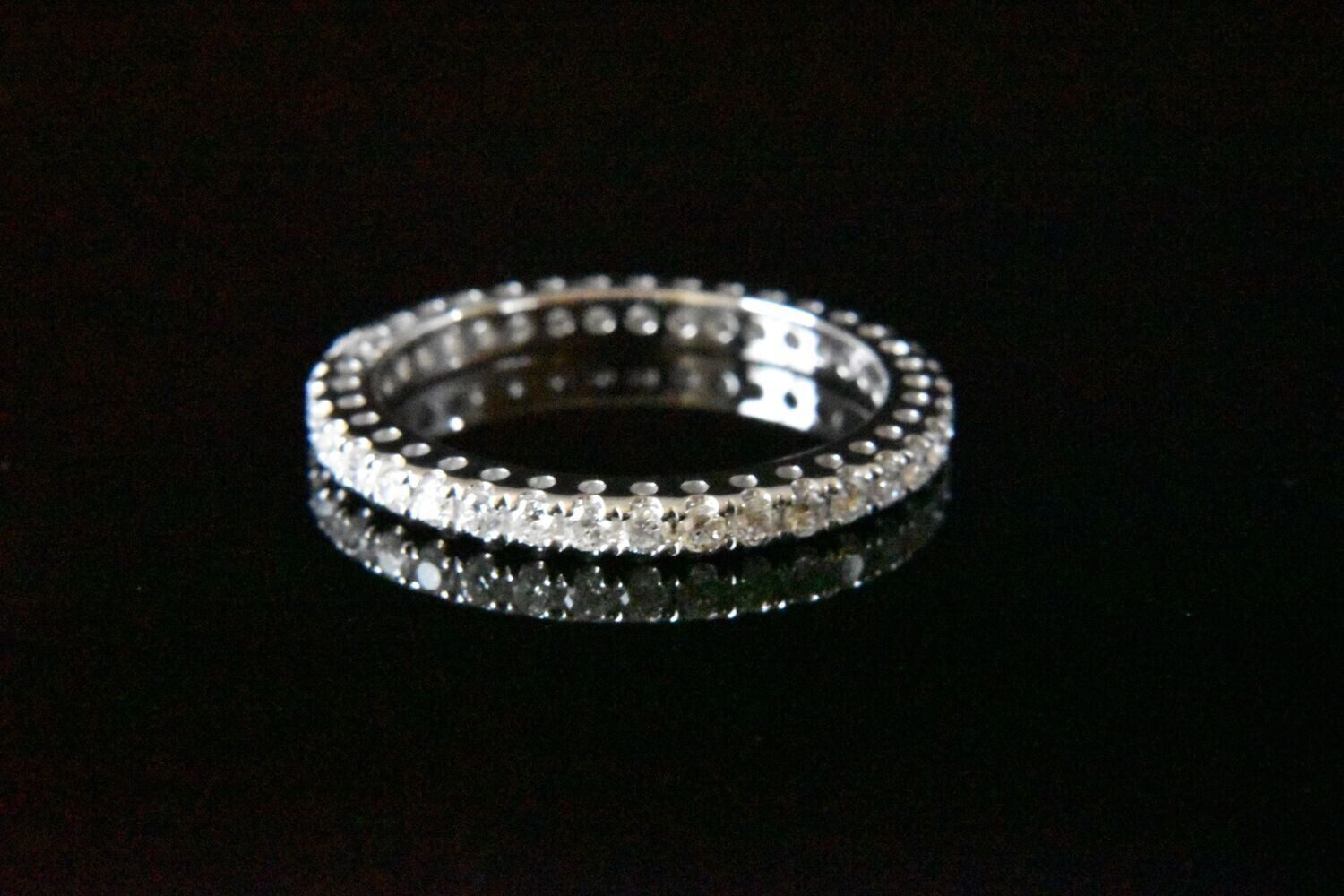 Diamond eternity band on black background.