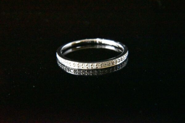 Diamond eternity band on black background.