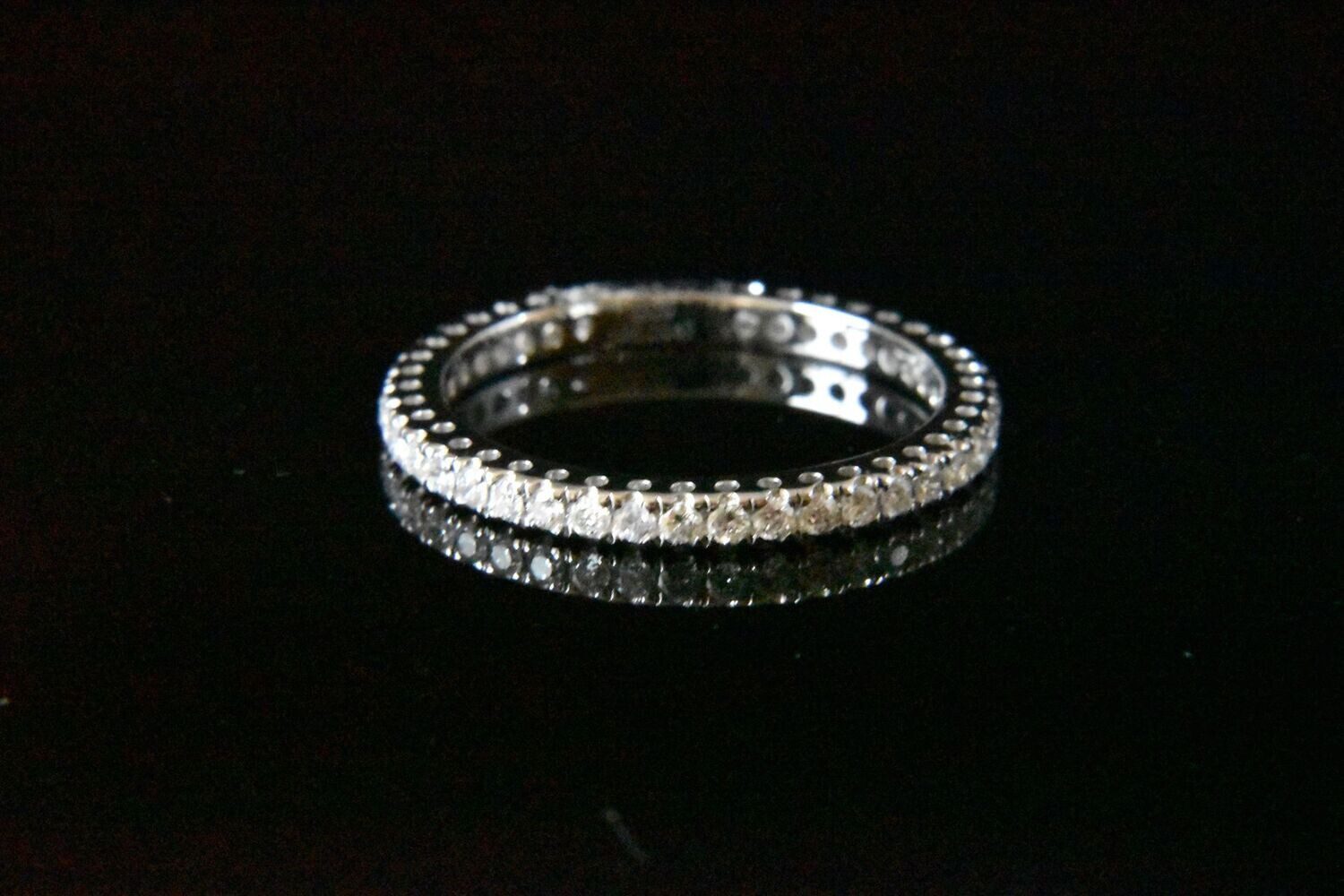 Diamond eternity band on black background.