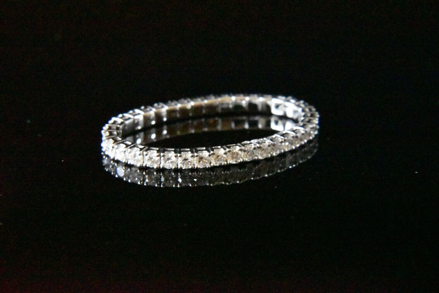 Diamond eternity band on black background.