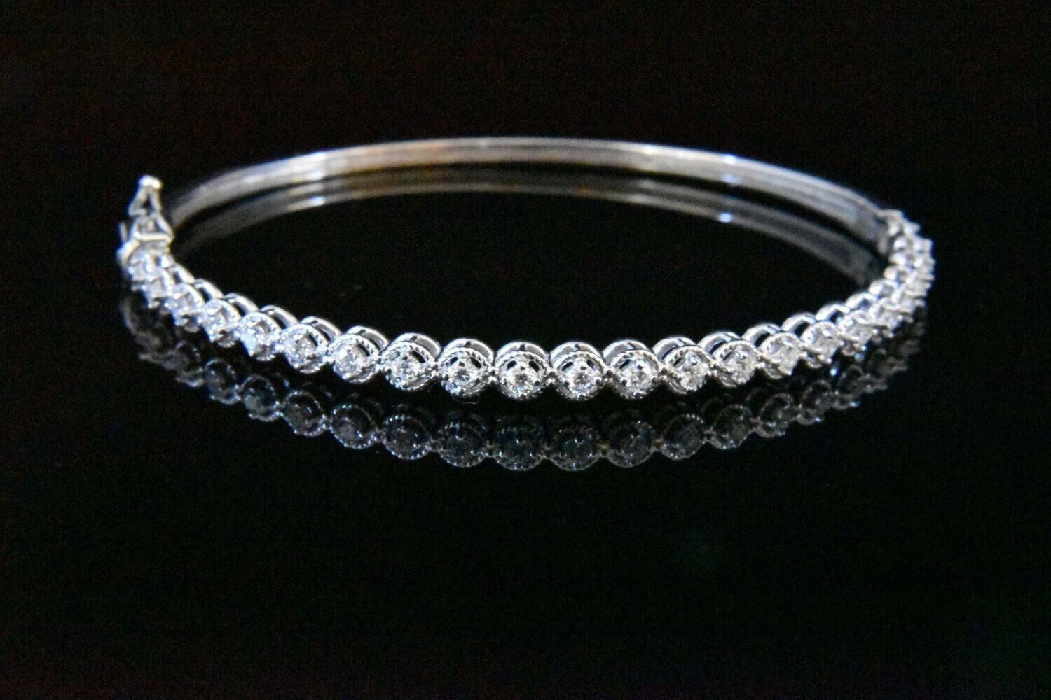 Diamond bangle bracelet on black background.