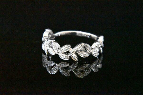 Diamond leaf ring on black background.