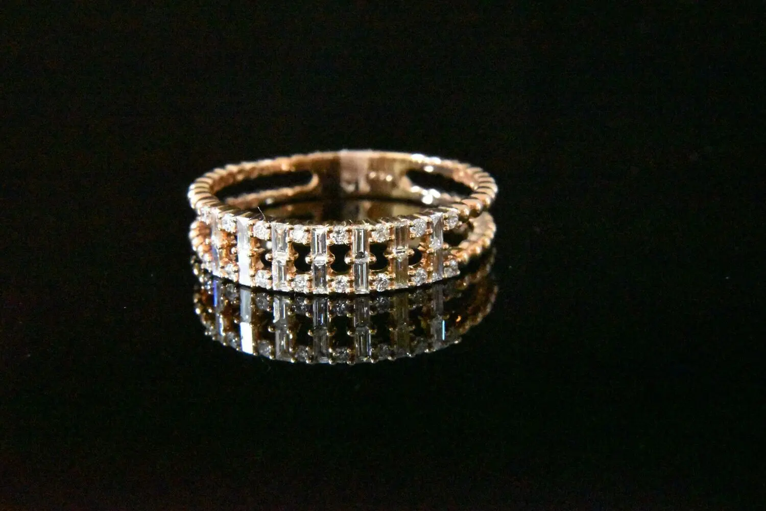 Diamond baguette ring on black background.