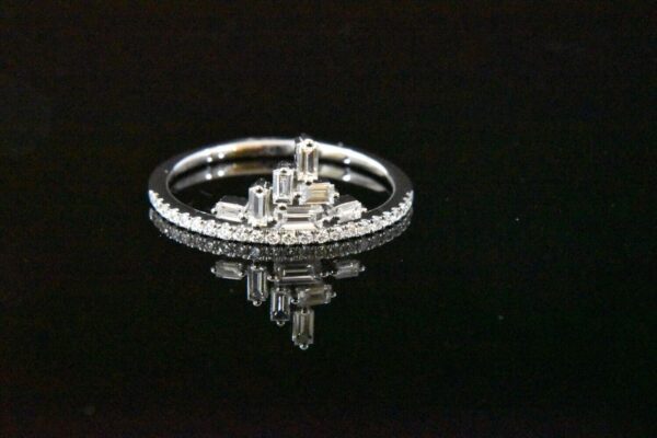 Diamond baguette ring on black background.