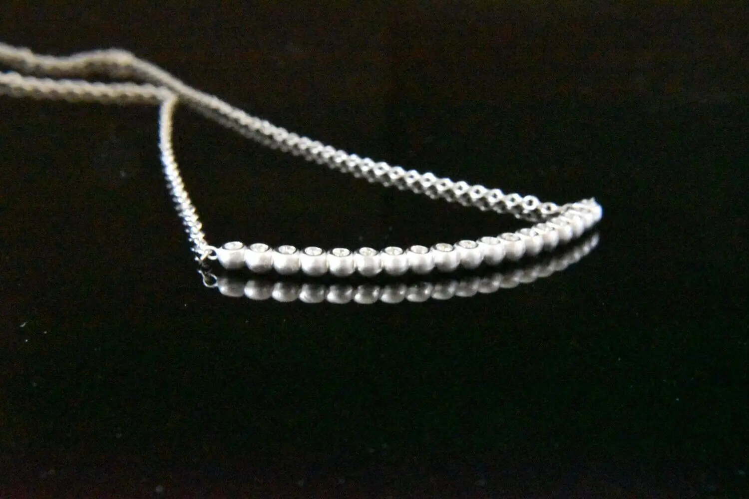 Silver beaded necklace with diamonds.