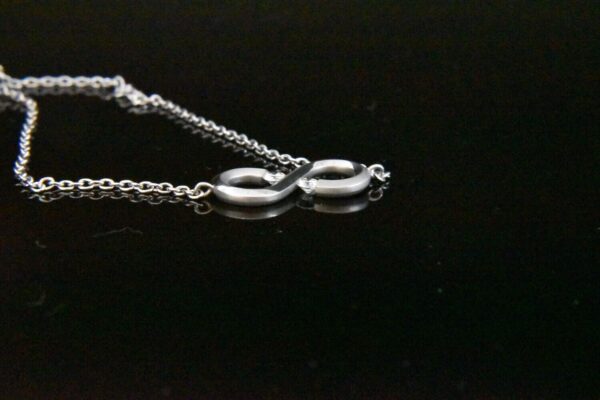 Silver infinity necklace with small diamonds.