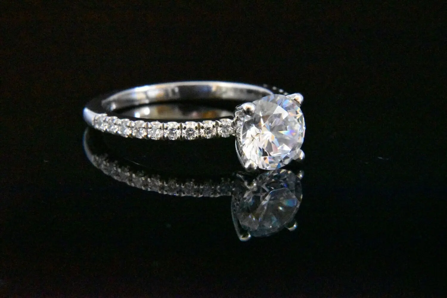 Diamond solitaire engagement ring with pave band.