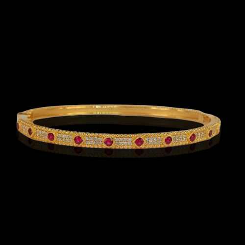 Gold bangle with ruby and diamond accents.