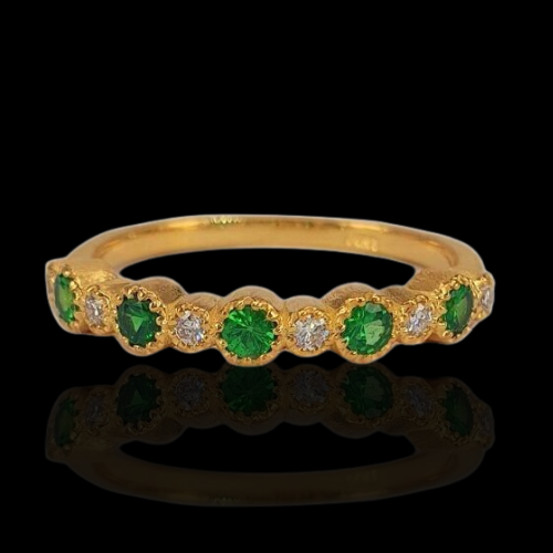 Gold ring with green and white stones.