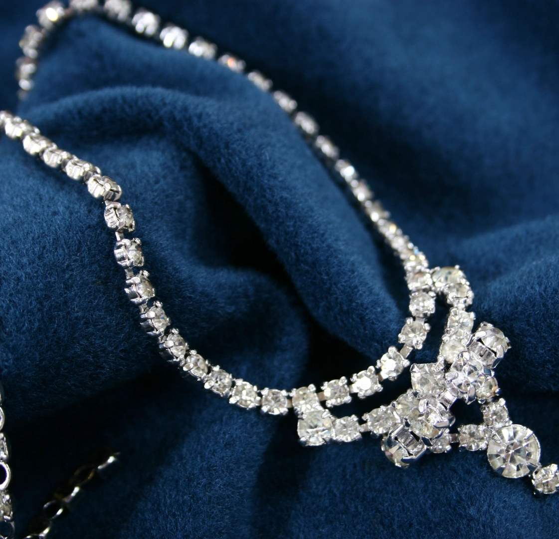 Sparkling rhinestone necklace on blue fabric.