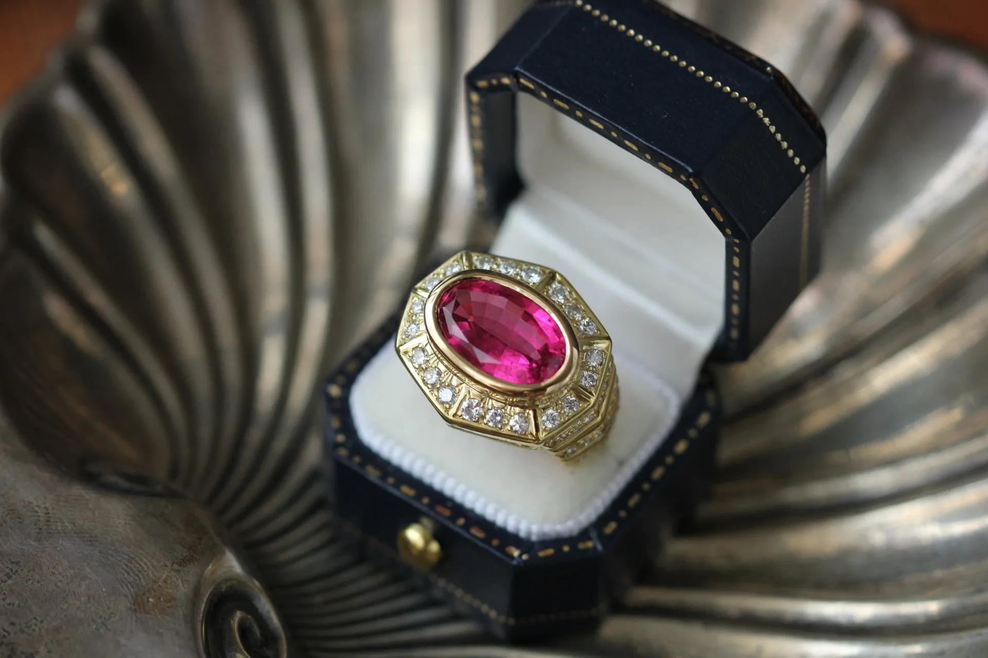 A gold ring with a pink stone in it.